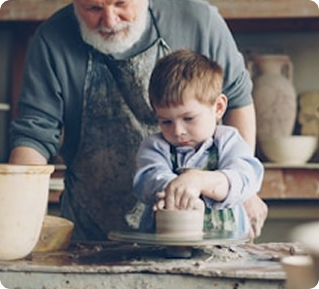 Homme et petit-fils travaillant l'argile ensemble - Atelier parent-enfant poterie